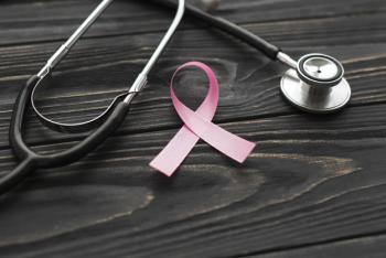 foto con stetoscopio e un nastro rosa intrecciato simbolo di prevenzione contro i tumori